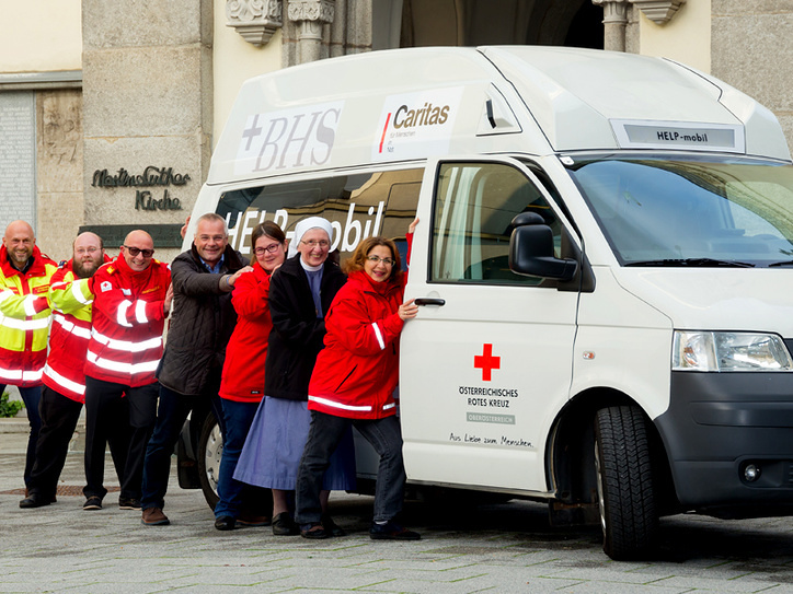 Die Caritas, der Arbeitersamariterbund Linz, der Orden der Barmherzigen Schwestern, der Hilfsdienst des Lazarus-Ordens und das Rote Kreuz Linz tragen das Help-Mobil. / © ÖRK LVOÖ / Werner Asanger
