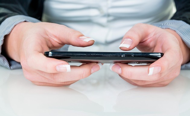 Eine Frau schreibt auf einem Smartphone / bilderbox.com / Erwin Wodicka
